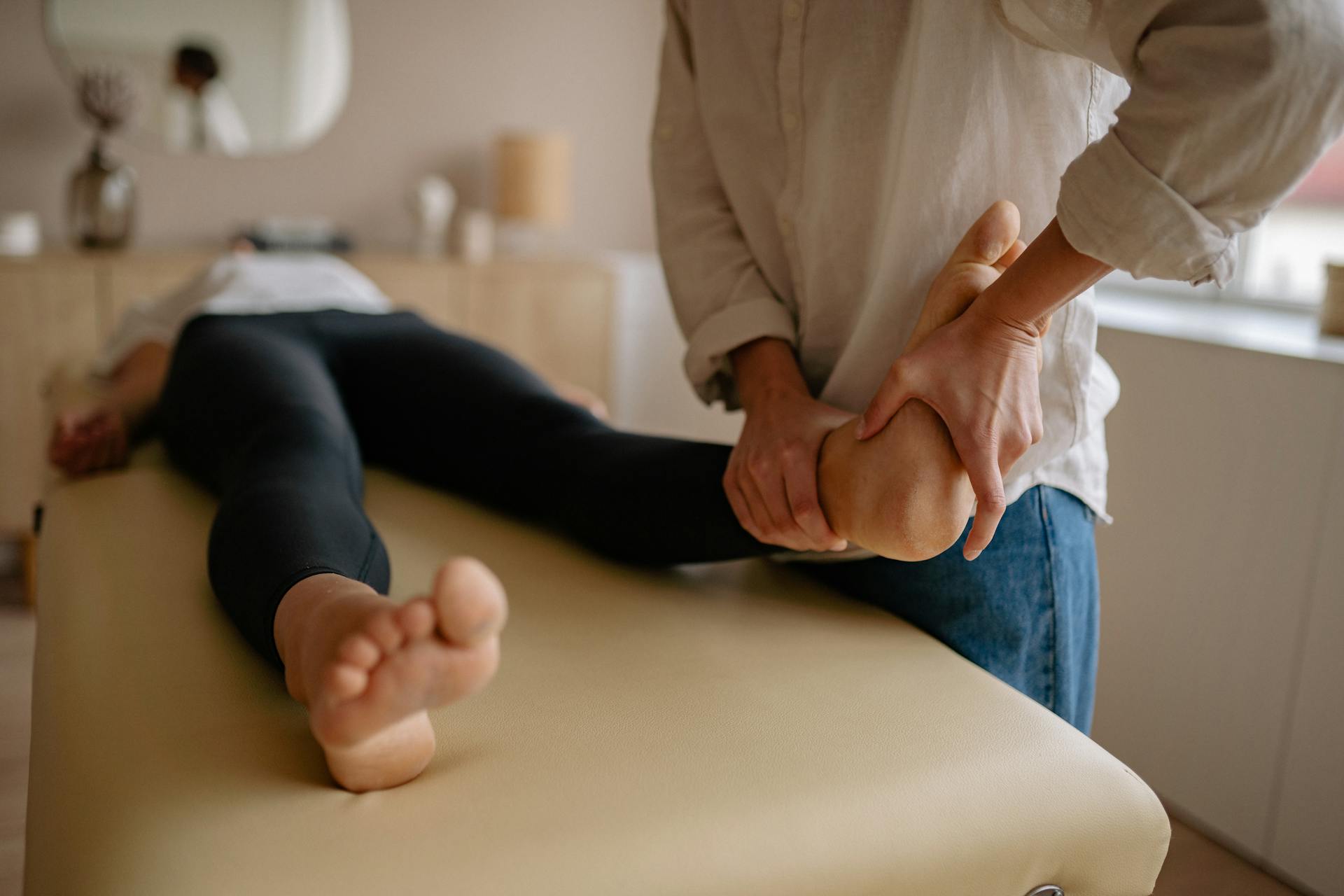 A podiatrist performing a close-up foot massage to relieve pain and improve circulation.