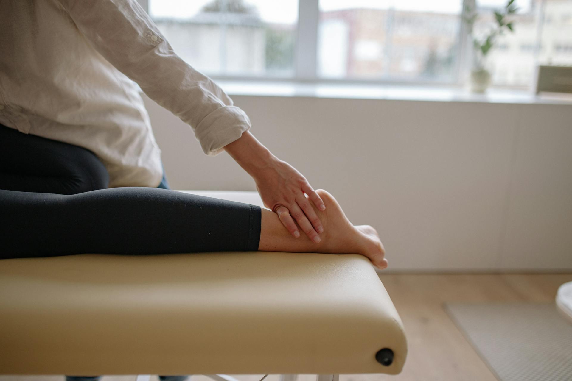 A podiatrist gently massaging a patient’s foot to promote relaxation and relieve pain.
